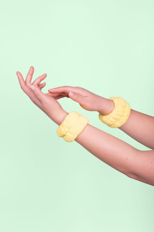 Pair of yellow spa wash wristbands shown on female wrists