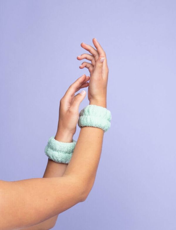 Pair of green mint face washing wrist towels shown on female wrists