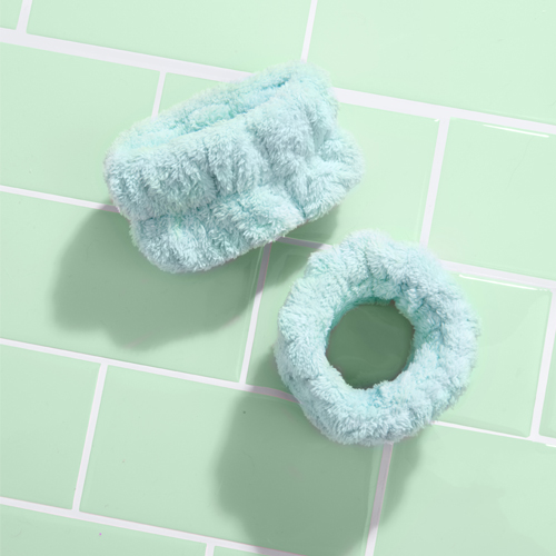 Pair of green mint arm sleeves for washing face on green bathroom tiles