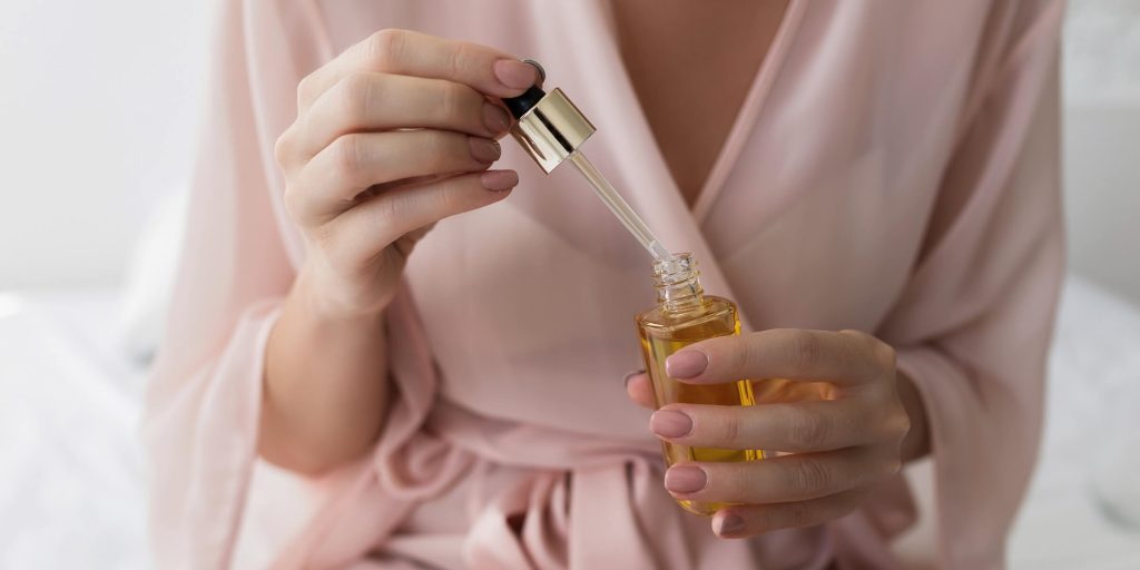 Women using face serum through dropper