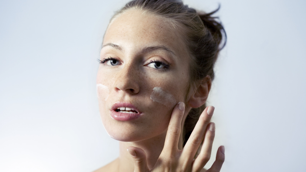 girl putting moisturiser on face