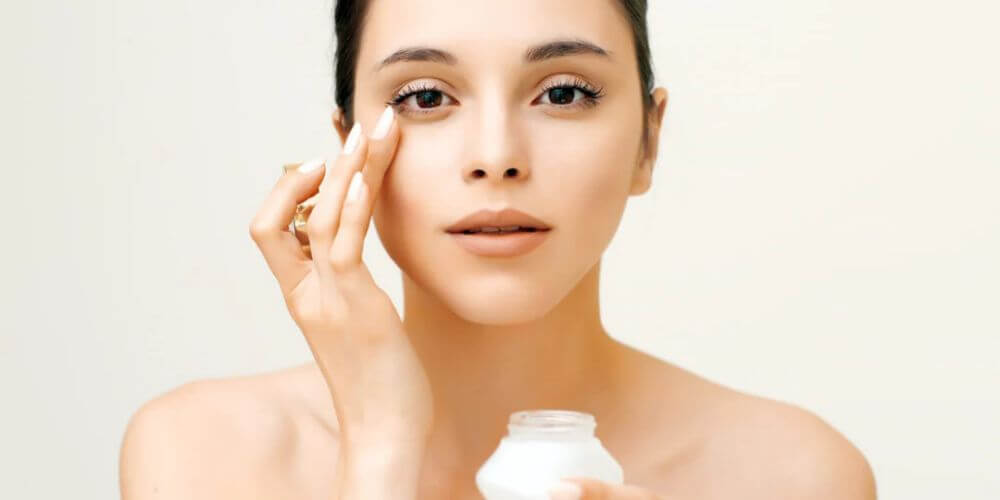 Women moisturizing her skin with cream